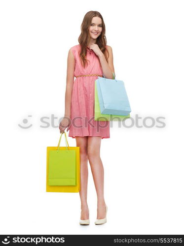 retail and sale concept - smiling woman in dress and high heels with many shopping bags