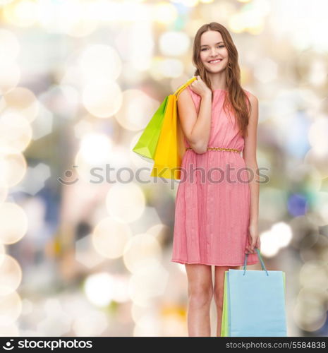 retail and sale concept - smiling woman in dress and high heels with many shopping bags