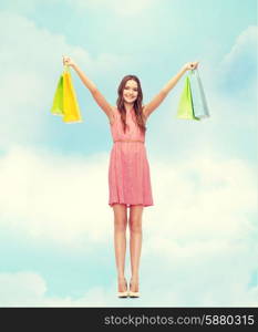 retail and sale concept - smiling woman in dress and high heels with many shopping bags