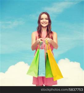 retail and sale concept - smiling woman in dress with many shopping bags