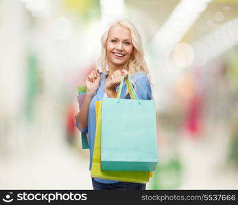 retail and sale concept - smiling woman with many shopping bags