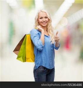 retail, gesture and sale concept - smiling woman with many shopping bags showing thumbs up