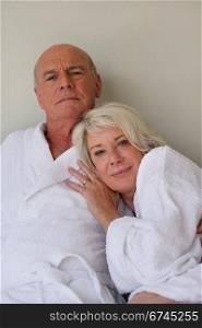 Retired couple sat in bathing robes