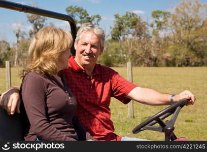 Retired middle aged couple having fun outdoors together. Room for text.