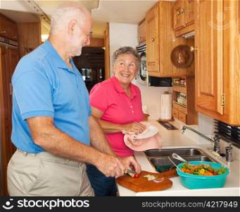 Retired senior couple in the kitchen of their RV camper.