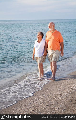 Retired senior couple takes a romantic stroll on the beach.