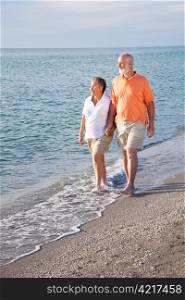 Retired senior couple takes a romantic stroll on the beach.