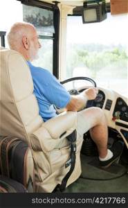 Retired senior man driving his motor home on vacation.