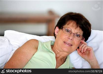 Retired woman propped up against some cushions