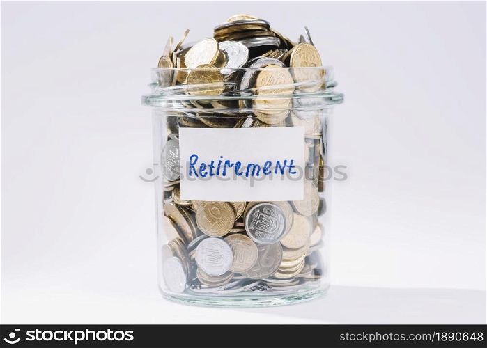retirement glass container full coins white backdrop . Resolution and high quality beautiful photo. retirement glass container full coins white backdrop . High quality and resolution beautiful photo concept
