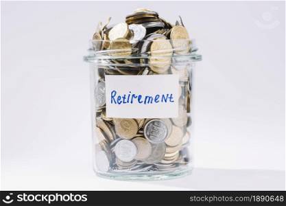 retirement glass container full coins white backdrop . Resolution and high quality beautiful photo. retirement glass container full coins white backdrop . High quality and resolution beautiful photo concept