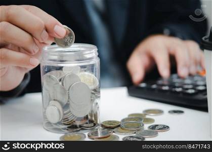 Retirement planning or investment accounting business concept finance insurance tax. Businessman person holding saving coin money in jar and calculator at desk.