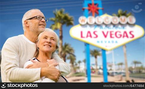 retirement, vacation, tourism and travel concept - happy senior couple hugging over welcome to fabulous las vegas sign background. senior couple traveling to las vegas. senior couple traveling to las vegas