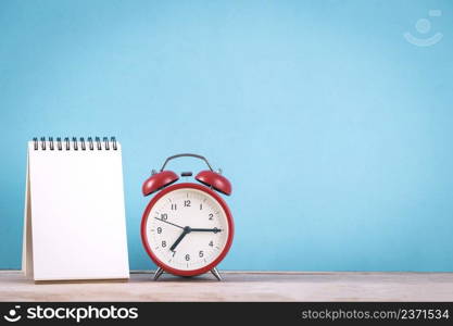 Retro alarm clock and blank note paper for text on wooden table with vintage style