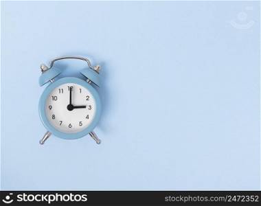 Retro alarm clock on blue background. Monochrome simple flat lay with copy space. Time concept. Stock photography.. Retro alarm clock on blue background. Monochrome simple flat lay with copy space. Time concept. Stock photo.