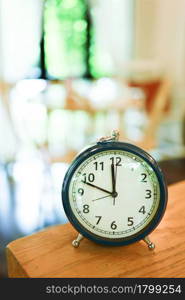 Retro Alarm clock on table in living room. vintage style Time of day .