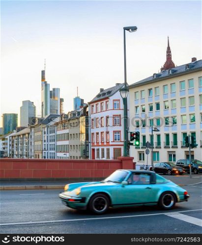 Retro automobile in the evening street of Frankfurt metropolis downtown, Germany