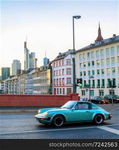 Retro automobile in the evening street of Frankfurt metropolis downtown, Germany