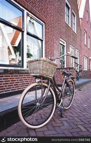 retro bike with basket standing on a street of amsterdam