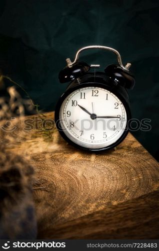 Retro black alarm clock on wooden night stand, vintage ols scool design background moody style. Retro black alarm clock on wooden night stand, vintage ols scool design background