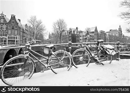 Retro black and white picture from snowy bicycles in Amsterdam city center the Netherlands