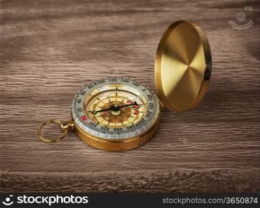 Retro brass compass on a wooden background
