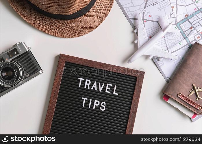 Retro camera with toy plane, map and passport on white background, Travel tips concept