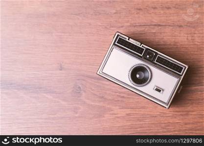Retro classic 35mm photo camera on wooden Background