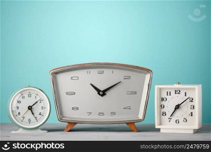 Retro clocks in a row on a table with blue background time concept