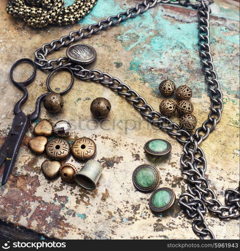 Retro crafts from beads.. Set of beads and chains for crafts located on metal background