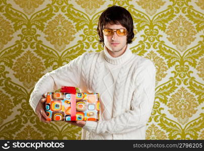 retro hip young man glasses holding psychedelic gift box on wallpaper