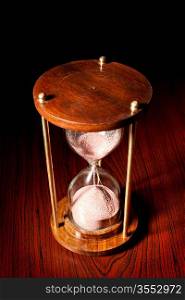 Retro hourglass (sand timer) on wooden table