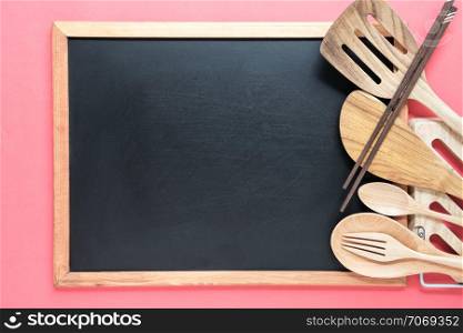 Retro kitchen utensils with empty blackboard on pink background. Food conceptual.