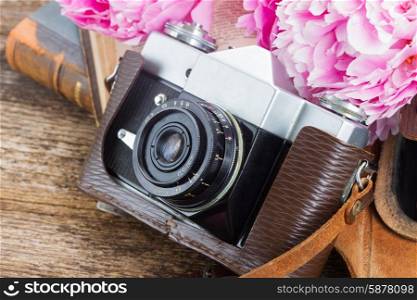 retro photo camera. retro photo camera with books and peony flowers