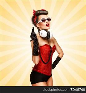 Retro photo of a glamorous pin-up girl with big vintage unplugged music headphones on colorful abstract cartoon style background.