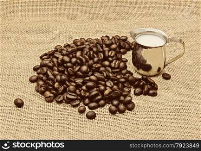 Retro photo of coffee beans on burlap background.