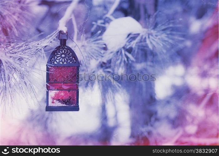 Retro photo of red lantern on the snowy tree