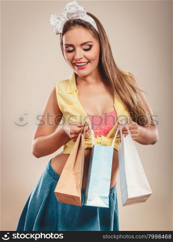Retro pin up girl shopping. Retro pin up girl shopping. Woman loking into paper bags.