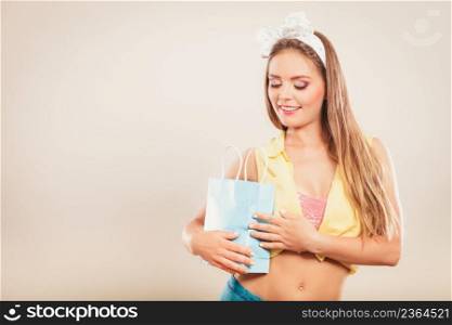 Retro pin up girl shopping. Woman looking into paper bag.. Retro pin up girl shopping
