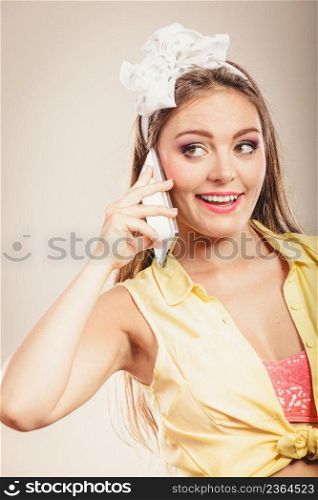 Retro pin up girl talking on mobile phone. Woman with cellphone using technology.