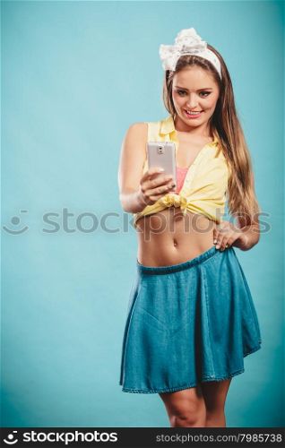 Retro pin up girl using moblie taking self photo selfie. Humor technology.