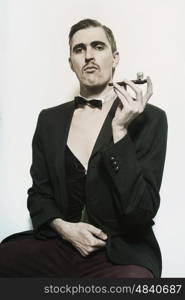 Retro portrait of an adult man smoking a pipe closeup