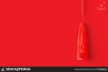 Retro red phone reciever on red background.