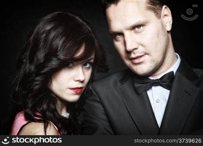 Retro style attractive couple in love, rich gangster with charming woman on black background