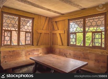 Retro style dining room interior with wooden table, walls and benches, depicting the rural life in the past.