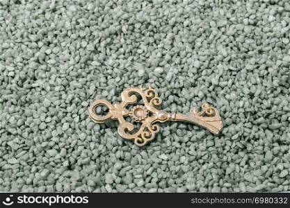 Retro style gold color key on green sand