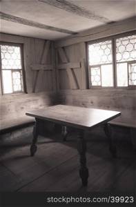 Retro style image with monochrome settings of an aged dining room interior with wooden furniture, walls and floor, depicting the rural life in medieval times.