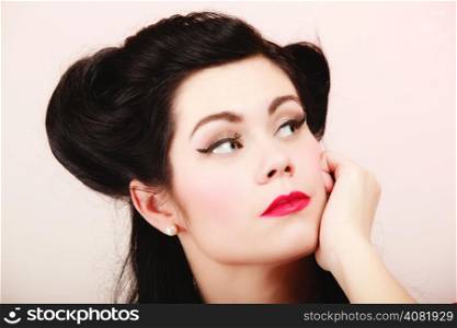 Retro style. Portrait of pensive woman dreaming on pink. Face of thoughtful brunette pinup girl thinking.
