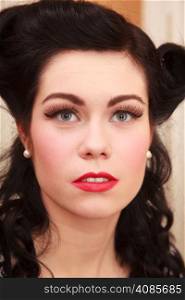 Retro style. Portrait of stylish young woman. Face of brunette girl with pinup hairstyle and makeup.