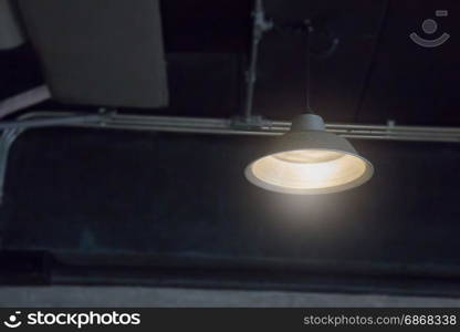 Retro styled light lamp in dark room, stock photo